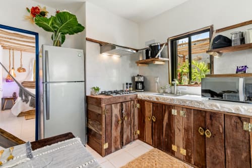 Modern kitchen in Casa Amor Ocean Front cottage, Isla Mujeres, featuring wood cabinetry, stainless appliances, and ocean