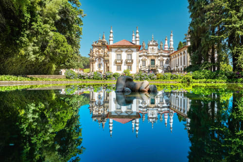 Palácio barroco refletido em água tranquila com árvores verdes, Casa da Avó Ana, Mondim de Basto Portugal