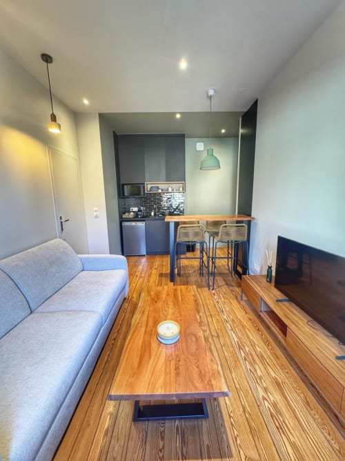 Studio moderne à l'hôtel O LIT avec séjour ouvert, cuisine, parquet et mobilier contemporain