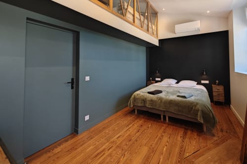 Chambre moderne à l'hôtel O LIT avec parquet, mur d'accent bleu-gris, lit queen-size et design minimaliste