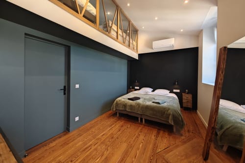 Chambre d'hôtel O LIT avec mur d'accent bleu, planchers en bois, lit queen-size et équipements modernes en France