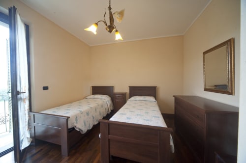 Chambre double avec lits en bois et mobilier sombre à la Villa Padronale d'Agriturismo Buriano, Lubriano, avec sol en parquet