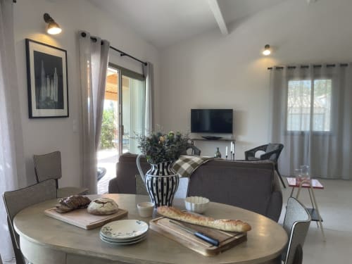Modernes Cottage Wohn- und Esszimmer mit rundem Tisch, TV, Gartenblick und Terrassenzugang in Gordes, Provence