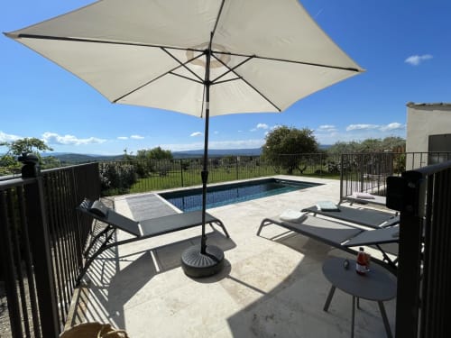 Terrasse mit Pool, Sonnenschirm und Liegestühlen mit Blick auf das Gordes-Tal, Provence