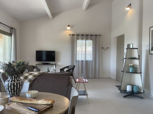 Modernes Cottages Wohnzimmer in Gordes mit grauem Sofa, Wand-TV und Gartenblick durch drapierte Türen