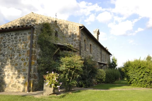Steinbauernhof des Agriturismo Buriano mit blühenden Pflanzen und gepflegten Gärten in Lubriano, Italien