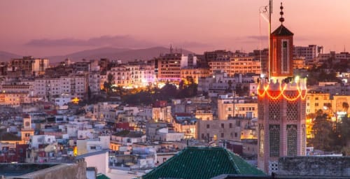 Vue du coucher de soleil sur la médina d'El Ghazouane avec le minaret de la mosquée du Riad Eucalyptus illuminé, Maroc