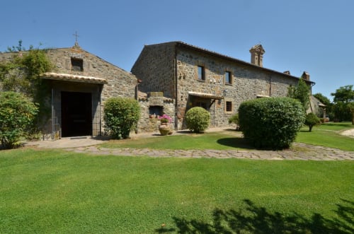 Steinbauernhaus mit gepflegtem Grüngelände im Agriturismo Buriano in Lubriano, Italien, mit rustikaler Architektur
