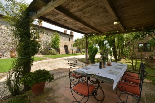 Essbereich im Freien des Agriturismo Buriano in Lubriano mit Steingebäuden, Pergola und rustikalen Sitzmöglichkeiten