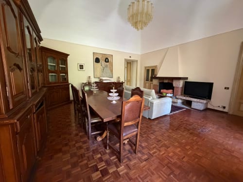 Ampio soggiorno e zona pranzo di Villa Mirano B&B a Piossasco con arredamenti in legno e camino