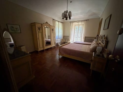 Camera elegante nella Villa Mirano B&B a Piossasco con arredamento in legno, lampadario e accesso al balcone