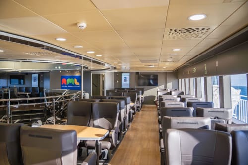 Intérieur moderne du salon du ferry avec sièges confortables et vue sur l'océan, transport vers El Ghazouane, Maroc