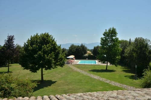 Agriturismo Buriano's grounds in Lubriano with swimming pool, manicured lawn, and mountain views