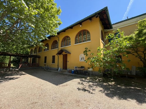 Villa Mirano B&B gialla a Piossasco con finestre ad arco, vista giardino e corte in ghiaia