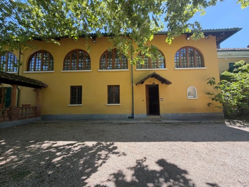 Villa gialla con finestre ad arco e edera verde presso la Villa Mirano B&B a Piossasco, Italia
