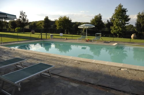 Agriturismo Buriano swimming pool in Lubriano with loungers, umbrella, and green countryside views