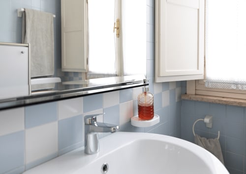 Bathroom at Cristallo Apartment in Ravenna featuring blue and white tiles, white sink, and modern amenities