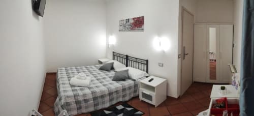 Camera doppia con letti singoli presso Royal House Fiumicino B&B. Dotata di angolo cottura, TV e arredi moderni