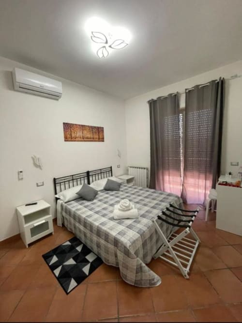 Camera doppia con letti singoli, angolo cottura e accesso al balcone presso Royal House Fiumicino B&B