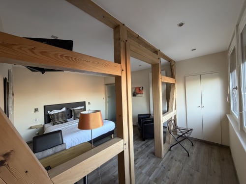 Chambre Tradition Double de l'Hôtel de l'Ange à Niedermorschwihr avec lit à baldaquin en bois, miroir, lampe et bureau