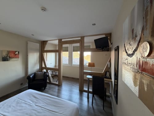 Chambre Tradition Double spacieuse à l'Hôtel de l'Ange à Niedermorschwihr avec lit, coin salon, bureau, TV et portes vitrées