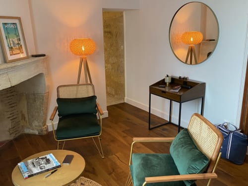 Retro 1930s-style bedroom at Le Prieuré de Saint-Pierre with green velvet chairs, orange tripod lamp, and round mirror in