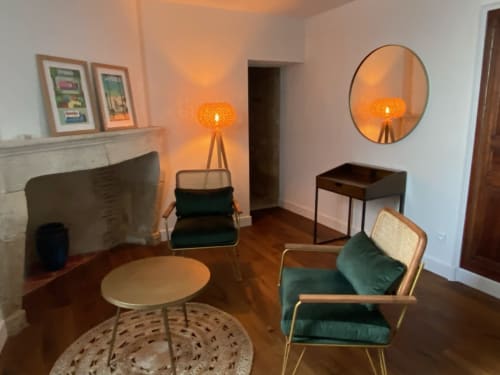 1930s-style bedroom at Le Prieuré de Saint-Pierre with green velvet chairs, round mirror, and ambient orange lighting