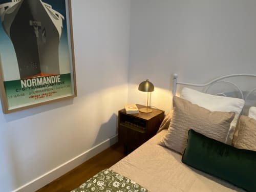 Cozy 30's-style bedroom at Le Prieuré with bedside lamp, vintage poster, and modern amenities