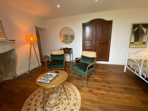 Vintage 1930s-style room at Le Prieuré with green velvet armchairs, round wooden table, and warm amber lighting