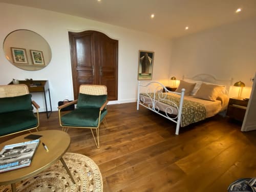 Spacious 1930s-style bedroom at Le Prieuré de Saint-Pierre with twin beds, green velvet chairs, and period décor in
