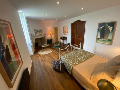 1930s-style bedroom at Le Prieuré de Saint-Pierre with bed, seating area, and period artwork