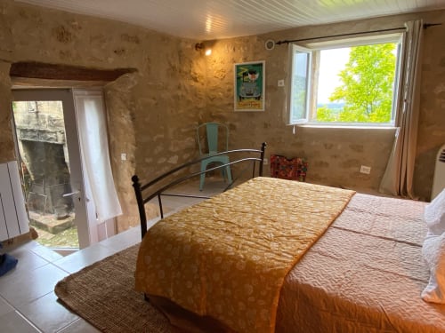 Retro 1950s bedroom at Le Prieuré de Saint-Pierre with garden view, metal bed frame, and patio access in Saint-Pey-de-Castets