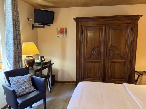 Chambre twin classique à l'Hôtel de l'Ange à Niedermorschwihr avec lit, fauteuil, armoire en bois et bureau