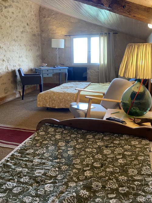 Chambre Le Prieuré at Le Prieuré de Saint-Pierre with patterned bedding, desk, armchair, and garden views