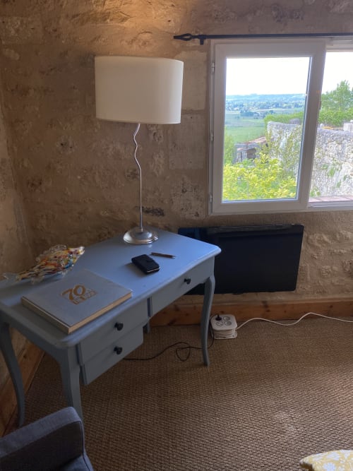 Bedroom workspace at Le Prieuré with desk, lamp, garden view window overlooking Saint-Pey-de-Castets countryside