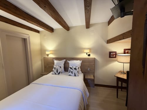 Chambre double classique de l'Hôtel de l'Ange avec poutres apparentes, lit queen-size, éclairage chaleureux et équipements modernes