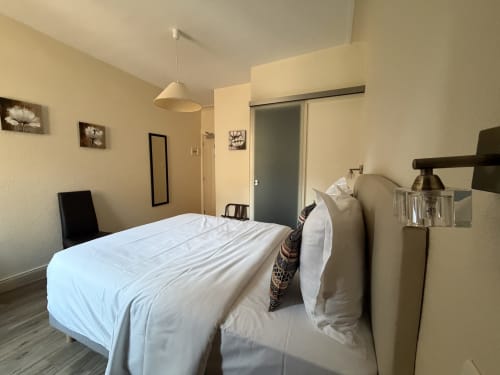 Chambre double moderne à l'Hôtel de l'Ange à Niedermorschwihr avec literie blanche, luminaire suspendu et salle de bains privée
