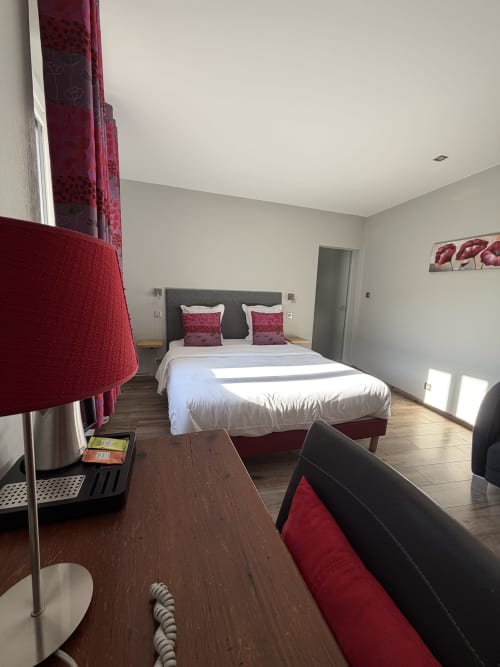 Chambre Tradition Double de l'Hôtel de l'Ange à Niedermorschwihr avec lit double, accents rouges et équipements modernes