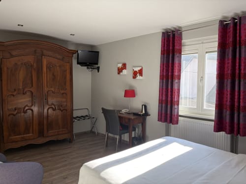 Chambre Tradition Double à l'Hôtel de l'Ange avec armoire en bois, bureau, téléviseur et rideaux bordeaux