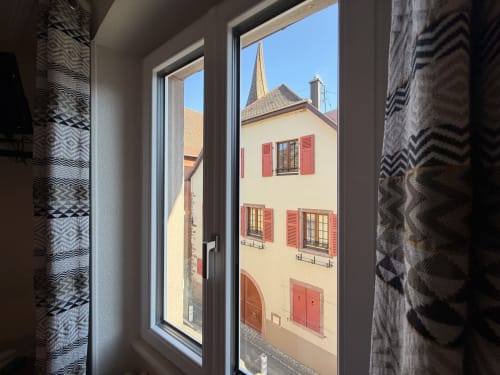 Vue depuis une chambre de l'Hôtel de l'Ange à Niedermorschwihr : charmant bâtiment du village français aux volets rouges