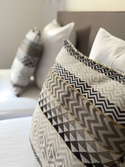 Coussin décoratif à motifs géométriques sur le lit de l'Hôtel de l'Ange à Niedermorschwihr, France