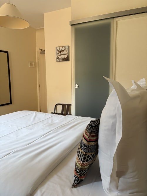 Chambre double de l'Hôtel de l'Ange à Niedermorschwihr avec literie blanche, lampe suspendue et équipements modernes