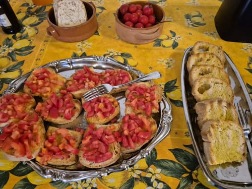 Bruschetta al pomodoro fresco e pane da Le Undici Lune a San Gimignano, su tovaglia con limone