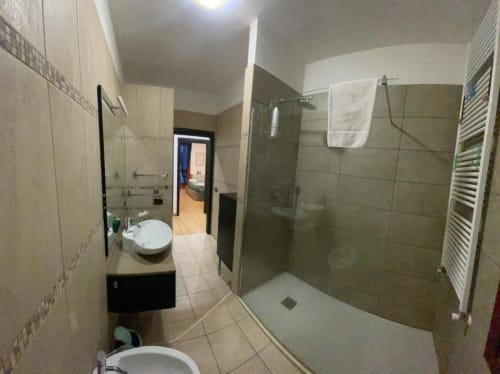 Bagno moderno con doccia walk-in, lavabo, toilet e scaldasalviette agli Appartamenti MiSaNi
