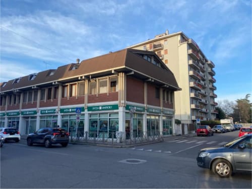 Residence MiSaNi con negozi al piano strada e auto parcheggiate in Italia