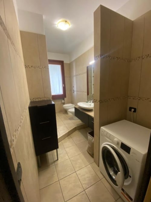 Bagno moderno degli Apartments MiSaNi con lavatrice, lavandino, WC e pareti piastrellate