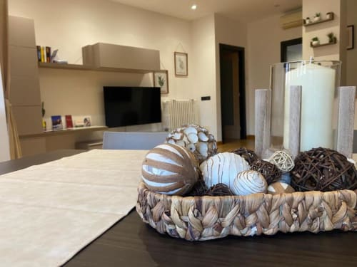 Soggiorno moderno di MiSaNi con televisore, cesto in legno con sfere decorative e arredi contemporanei