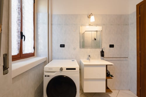 Moderno bagno a Centrale Bologna con lavatrice, lavabo, specchio e doccia in camera 28
