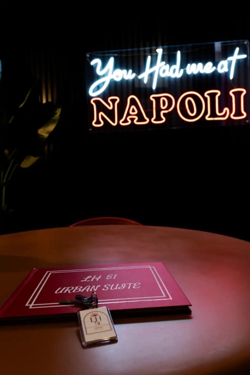 LH51 Urban Suite key card and menu at neon-lit Napoli restaurant with 'You Had me at NAPOLI' sign