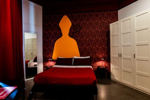 Suite moderna urbana presso LH51 Napoli con letto rosso, testata in arte arancione e design contemporaneo